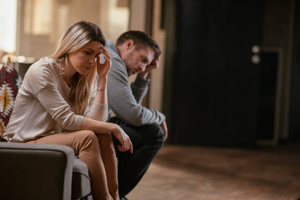 Tensed couple sitting on a couch