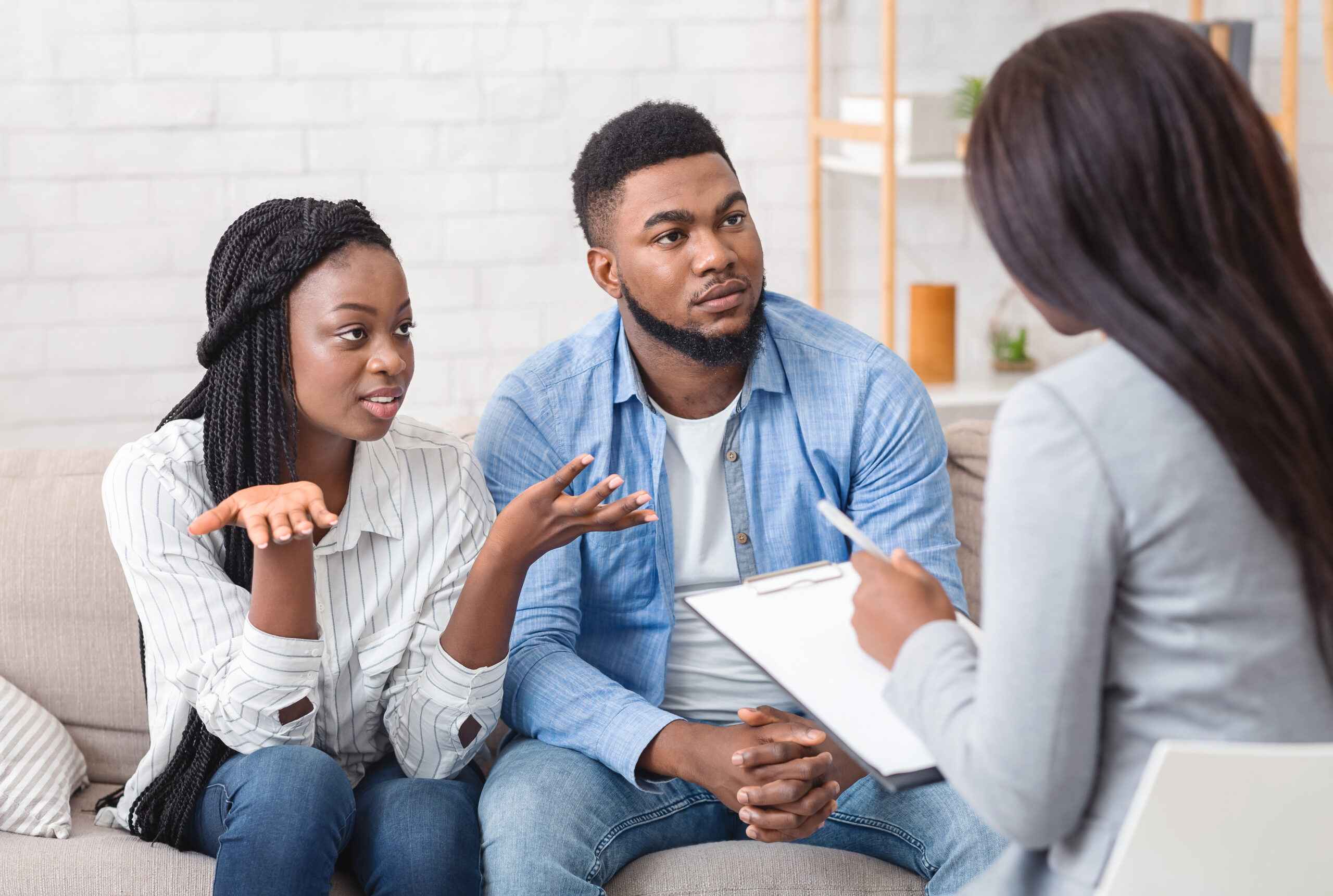 Couple sitting on a couch talking to a person